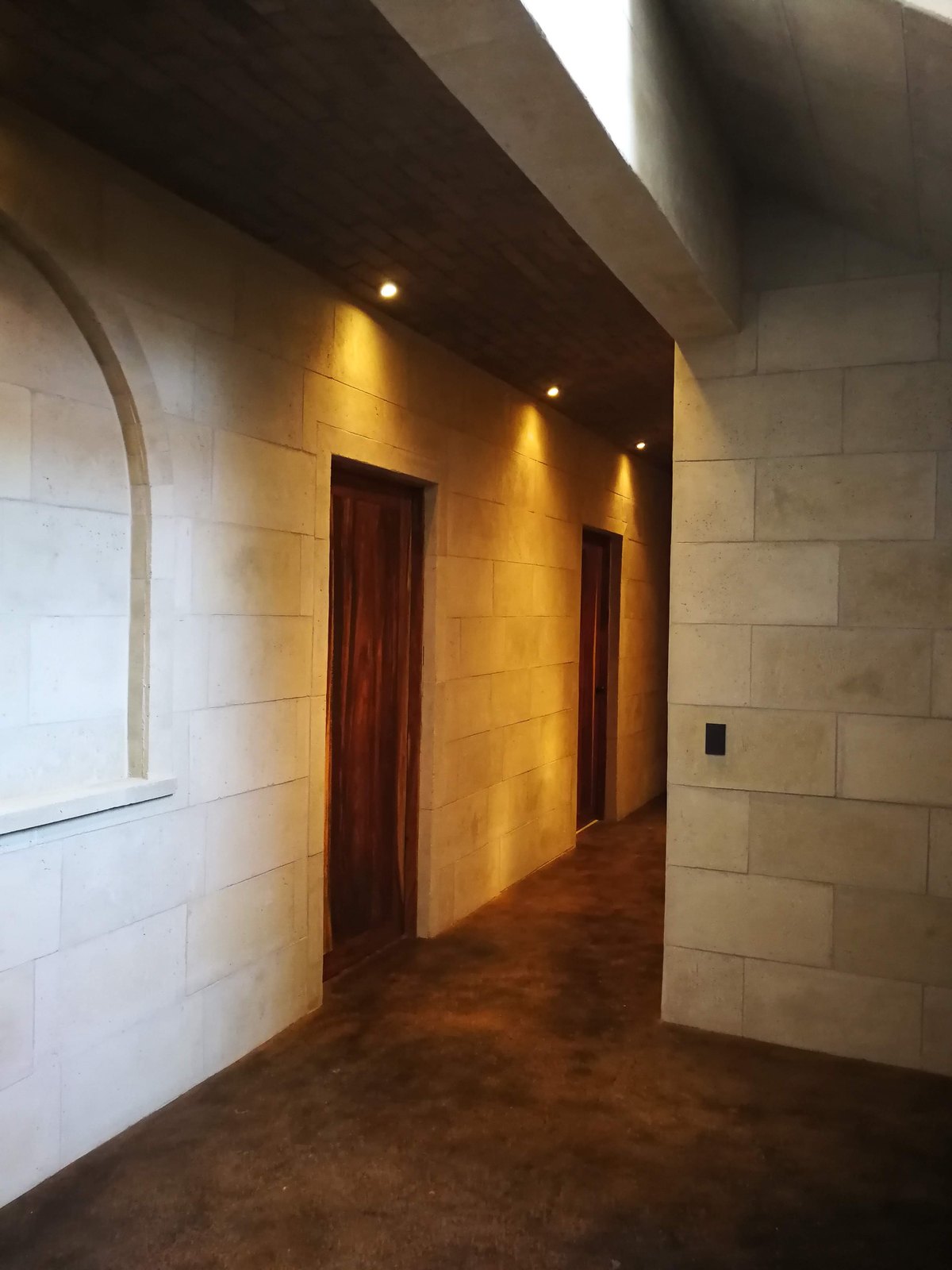 Pasillo con paredes de coralina prefabricada e iluminación cálida