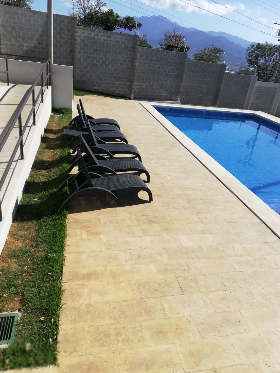 Piscina con borde de coralina prefabricada y camastros