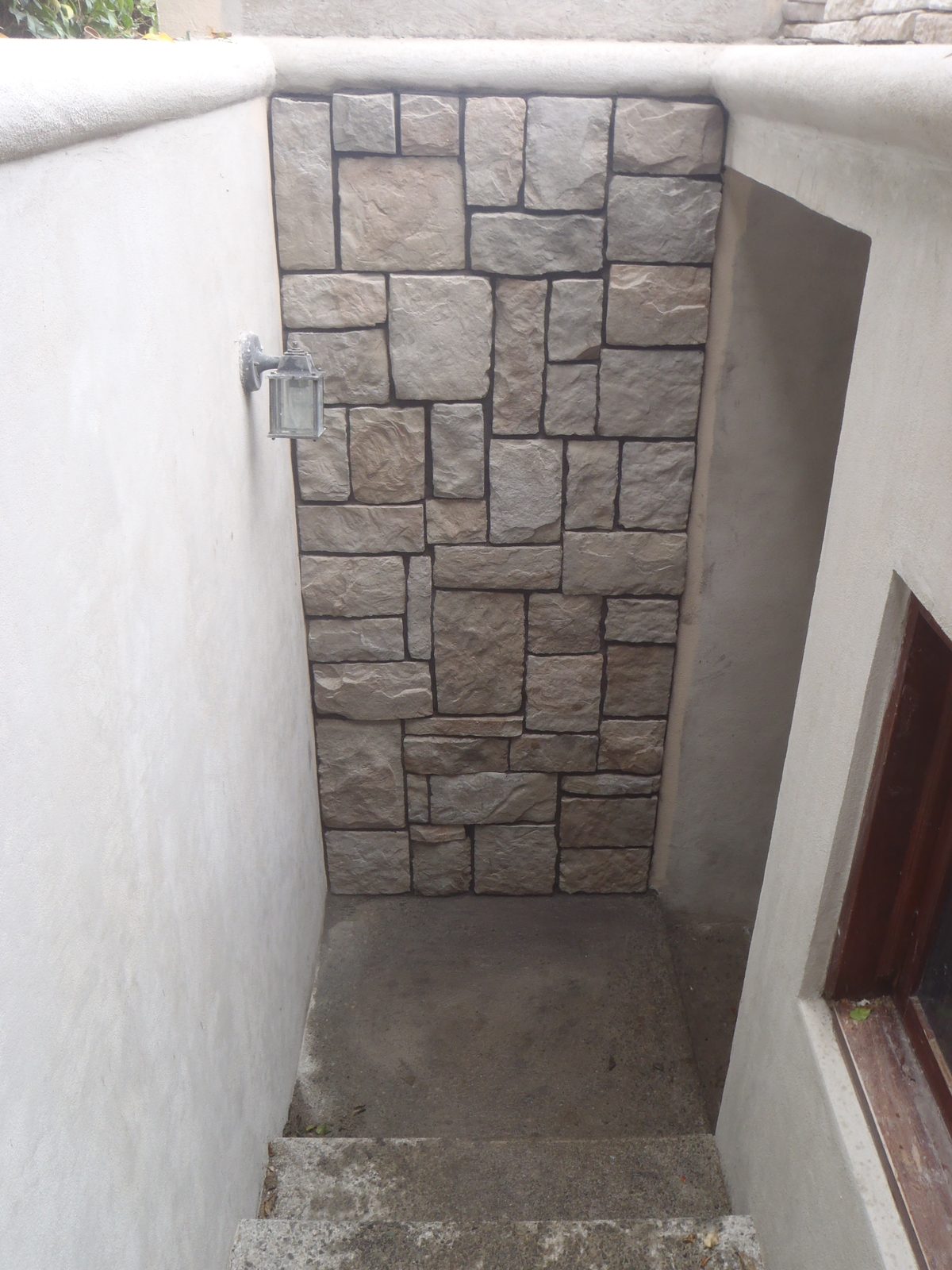 Muro de cochera revestido con piedra Hackett Ozark