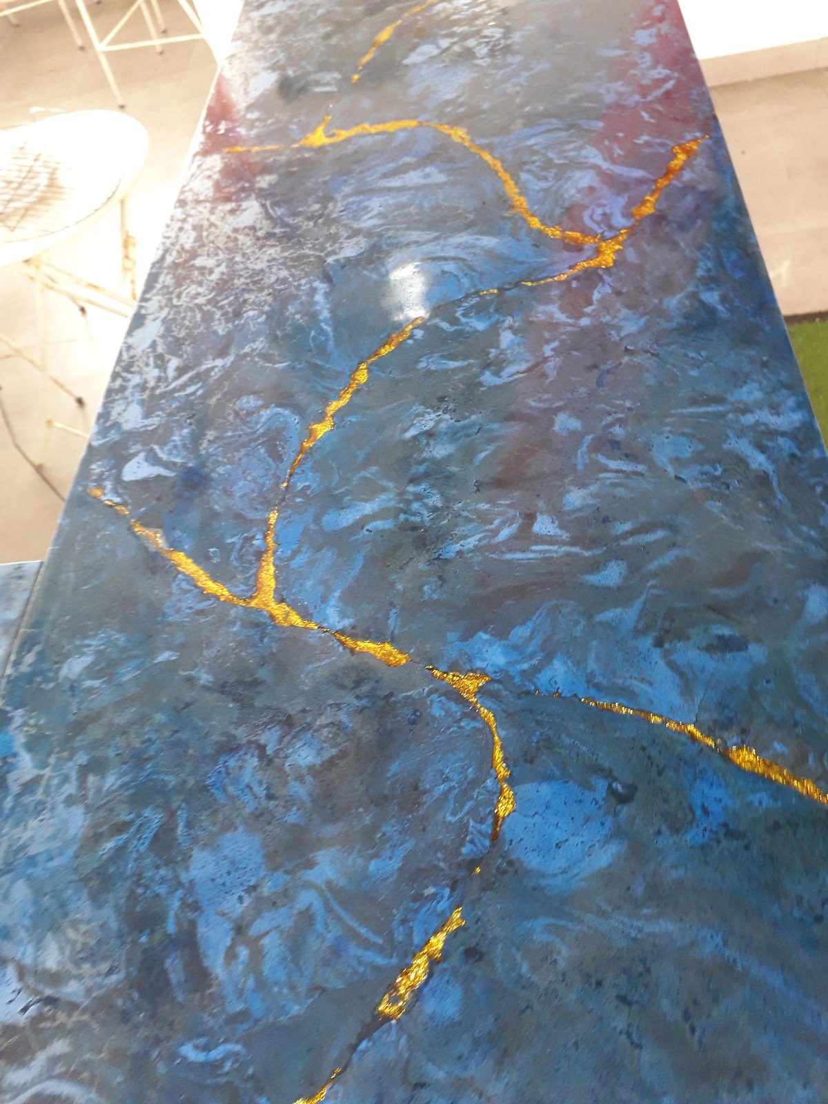 Acabado azul con vetas doradas sobre concreto