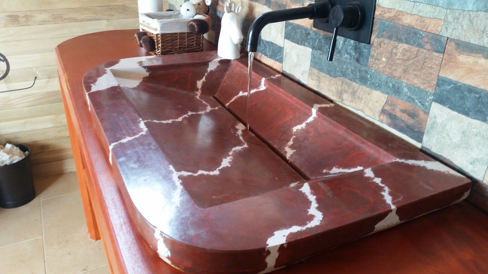 Detalle del veteado blanco sobre el rojo del lavamanos Florentina