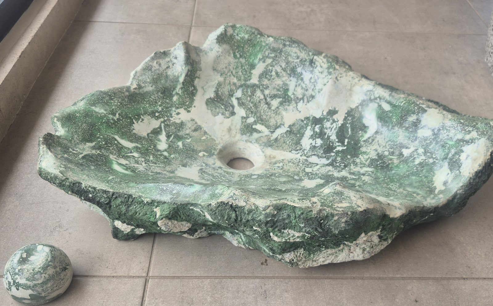 Lavamanos La Roca verde junto a su tapón esférico de concreto