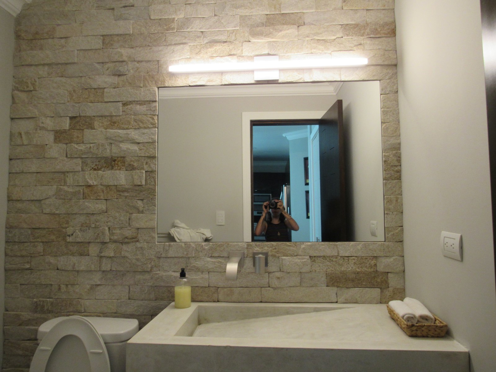 Baño completo con el lavamanos White Slope y muro de piedra apilada
