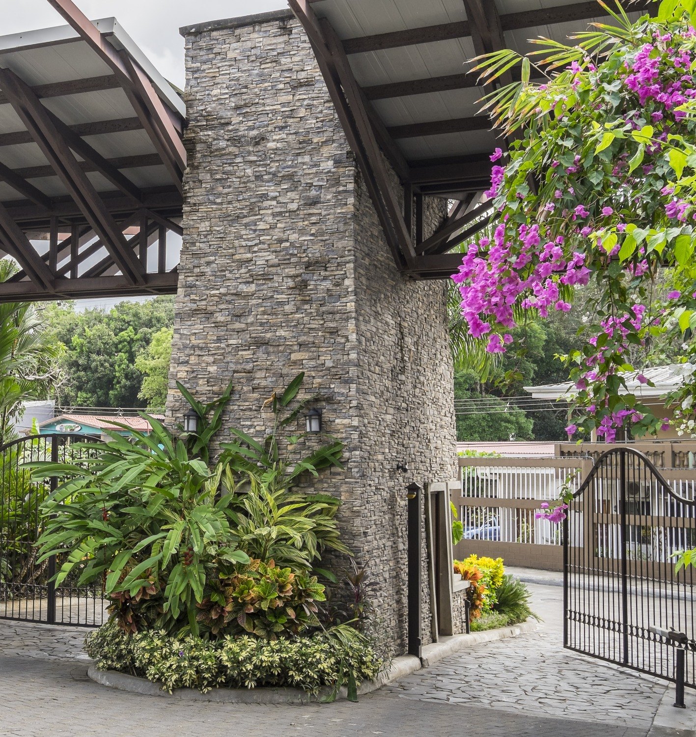 Portón de acceso con pilares de enchape de piedra, condominio frente al mar, Costa Rica — Deco Rock