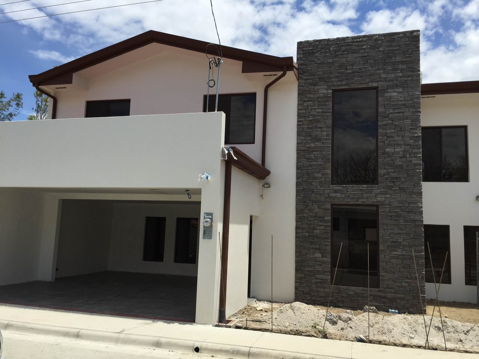 Casa de dos plantas con paño vertical de piedra QuickFit Grafito