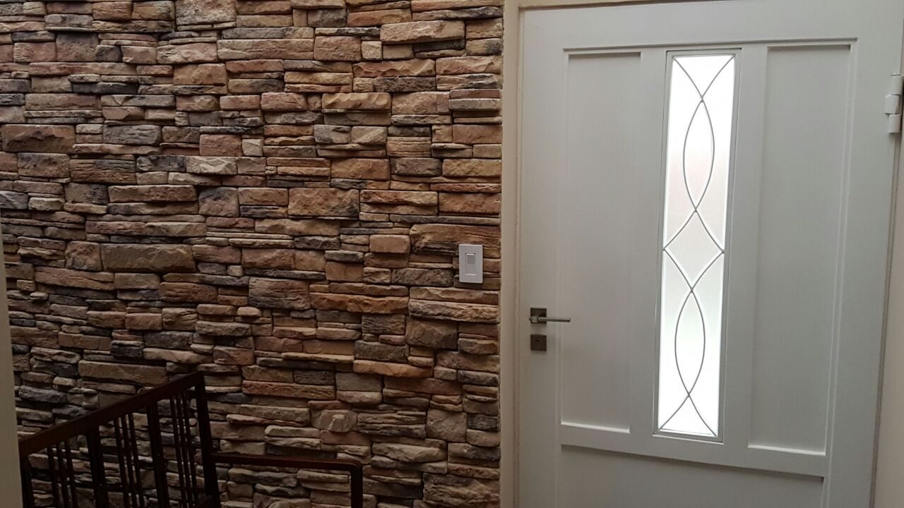 Muro de entrada revestido con piedra QuickFit Rustic en tonos tierra